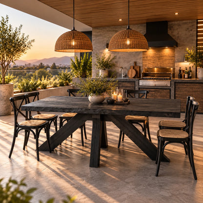 Comedor de terraza con mesa de madera carbonizada y sillas Cruzeta negras junto a quincho con parrilla – imagen referencial
