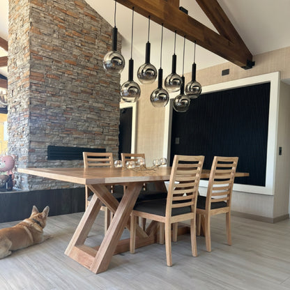 Mesa de comedor de madera Italia con sillas de madera en un living con chimenea