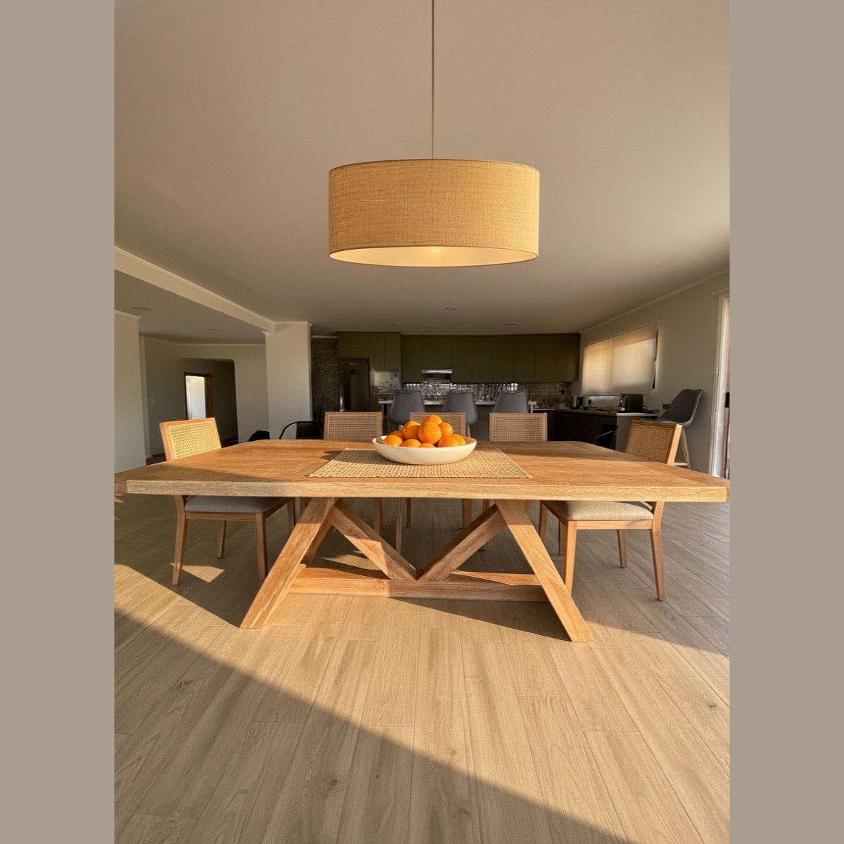 Mesa de comedor de madera Italia en un comedor luminoso con lámpara de lino