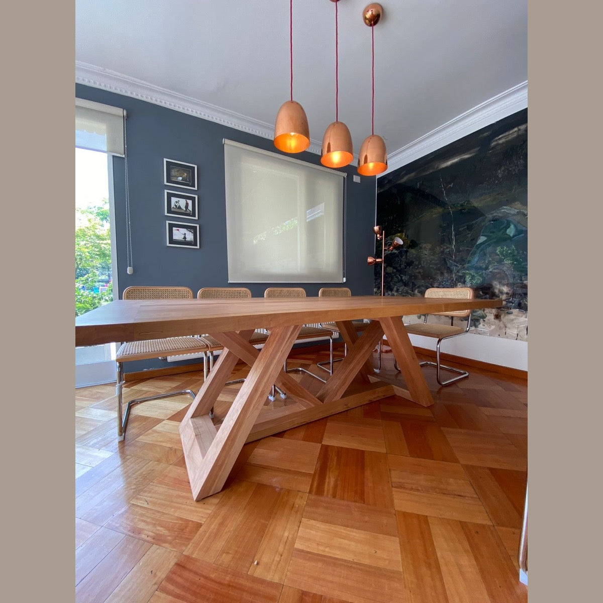 Mesa de comedor de madera Italia con lámparas de cobre y sillas de rattan