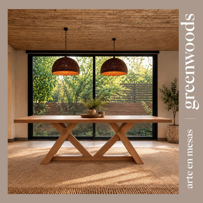 Mesa de comedor Italia de madera lenga con base en X, frente a un ventanal al jardín y lámparas de mimbre | Greenwoods Chile